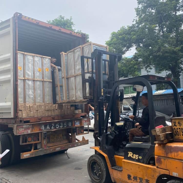 Forklift loading crates into shipping container